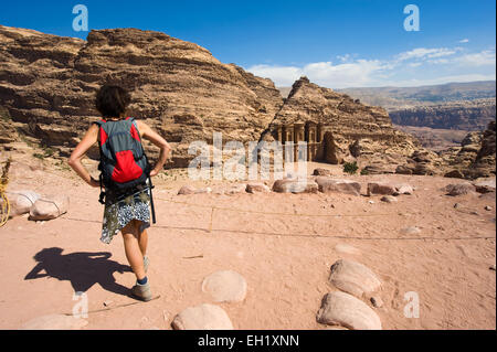 PETRA, JORDAN - OCT 12, 2014: A tourist is looking down from a hill to the Ad Deir monastery in Petra in Jordan