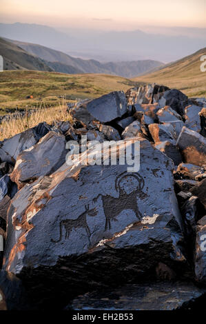 Ancient petroglyphs of animals on rock on Saimaluu Tash site in Kyrgyzstan Stock Photo