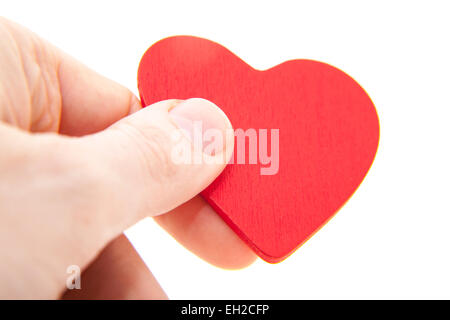 Human hand holding a red heart with a Christian cross isolated over ...