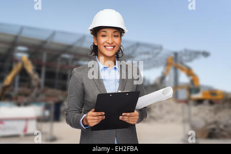 smiling architect in helmet with blueprint Stock Photo