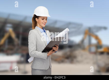 smiling architect in helmet with blueprint Stock Photo