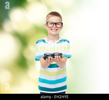 smiling boy in eyeglasses holding spectacles Stock Photo