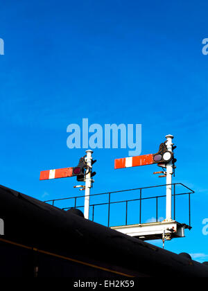 Railway semaphore stop signals against a blue sky on the Churnet Valley Railway, Staffordshire, England UK Stock Photo