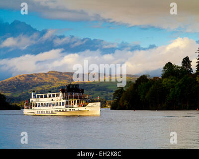 Passenger boat MV Teal sailing across Lake Windermere in the Lake District National Park with view of mountains in background UK Stock Photo