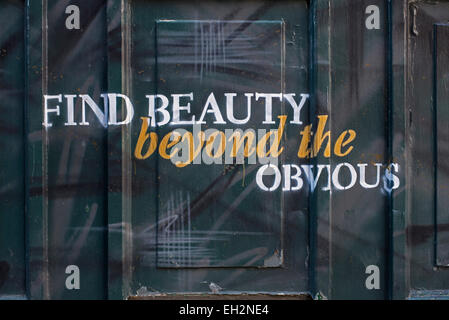 A painted panel on a Public House in Edinburgh with the words, 'Find beauty beyond the obvious'. Stock Photo