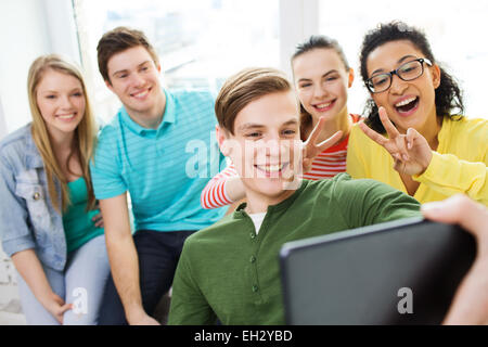 smiling students making selfie with tablet pc Stock Photo
