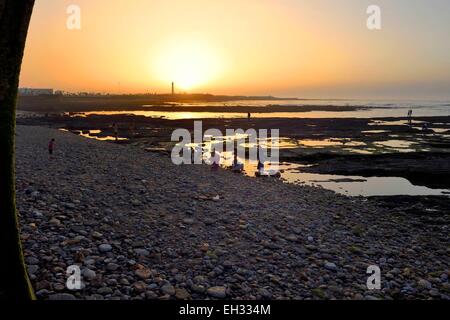 Morocco, Casablanca, the pebble beach of La Corniche and El Hank lighthouse in the background Stock Photo