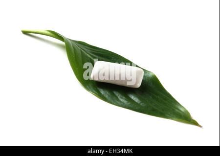 chewing gum on a green leaf isolated on a white background Stock Photo