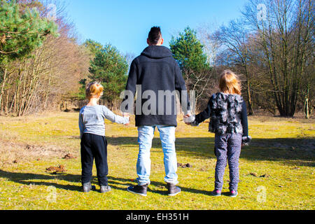 two girl and a big brother holding hands Stock Photo