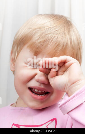 Closeup vertical portrait of blonde crying Caucasian baby girl Stock Photo