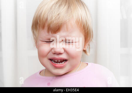 Closeup portrait of blonde crying Caucasian baby girl Stock Photo