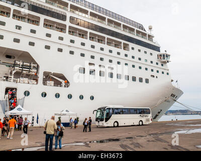 A tour bus arrives taking passengers to  board the MSC Armonia cruise ship docked at Cagliari port, Italy Stock Photo