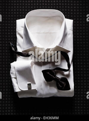 White Shirt with Double Cuffs and Black Bow Tie on Dotted Background Stock Photo