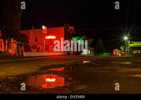 Classic western streetscape at night, with a neon Oregon Hotel sign lighting the sides of a building, in Mitchell, Oregon, USA Stock Photo