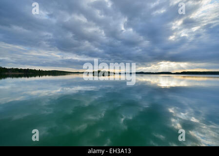 Clouds and crepuscular sunrays refelcted in lake at sunrise, Woerthsee Lake, Upper Bavaria, Fuenfseenland, Germany Stock Photo