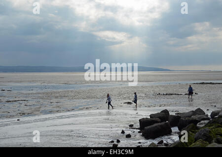 Three people on the beach at West Kirby, Wirral, Merseyside. Stock Photo