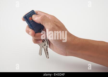 Hand press the remote control with keys in clean background Stock Photo