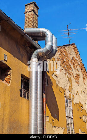 Steel pipes next to an old factory building Stock Photo