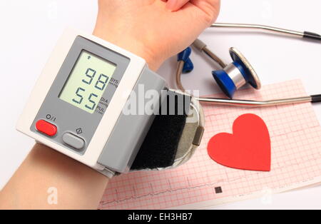 Measuring blood pressure, heart shape and stethoscope on electrocardiogram, medicine concept Stock Photo