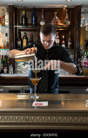 A male barman, bar tender, mixologist makes a fantastic cocktail in a high end restaurant / bar / public house Stock Photo