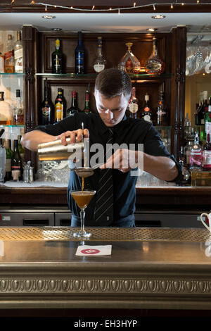 A male barman, bar tender, mixologist makes a fantastic cocktail in a high end restaurant / bar / public house Stock Photo