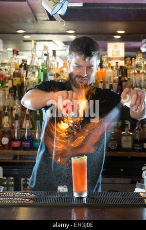 A male barman, bar tender, mixologist makes a fantastic cocktail in a high end restaurant / bar / public house Stock Photo