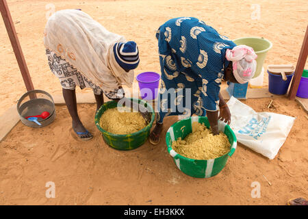 KOMOBANGAU, TILLABERI PROVINCE, NIGER, 15th May 2012: Women mix a food suppliment for malmouried children at the local health centre. Stock Photo