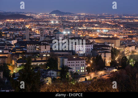 Bergamo, Italy - Aerial view of the old medieval city (Città Alta) and lower Bergamo at night. Stock Photo