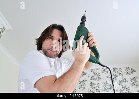middle-aged man with a drill in the hands of Stock Photo