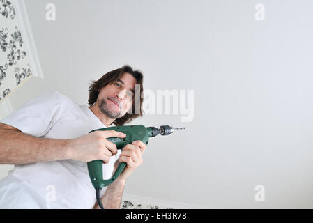 middle-aged man with a drill in the hands of Stock Photo