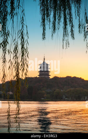 Chinese pagoda on the coast of West Lake. Famous park in Hangzhou city center, China. Colorful tonal photo filter Stock Photo