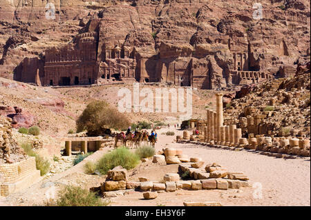 PETRA,  JORDAN - OCT 12, 2014: Roman pillars on colonnaded street, and the 'Royal tombs' on the background in the rocks in Petra Stock Photo