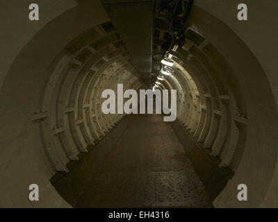 Section of Greenwich foot tunnel with silhouetted figures in the distance Stock Photo