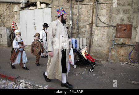 Jerusalem, Palestinian Territory. 6th Mar, 2015. Ultra-Orthodox Jews dressed in costumes as they walk on a sidewalk during celebrations marking the Jewish holiday of Purim in Jerusalem's Mea Shearim neighbourhood March 6, 2015. Purim is a celebration of the Jews' salvation from genocide in ancient Persia, as recounted in the Book of Esther Credit:  Muammar Awad/APA Images/ZUMA Wire/Alamy Live News Stock Photo