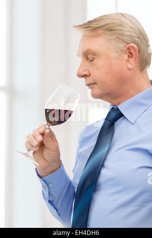 older man smelling red wine Stock Photo