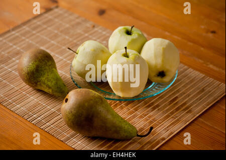 Peeled apples on glass plate and pears Stock Photo