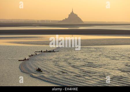 France, Manche, Mont Saint Michel bay, listed as World Heritage by UNESCO, a kayakists riding the Mascaret wave during fall high tides and Tombelaine islet in the background Stock Photo