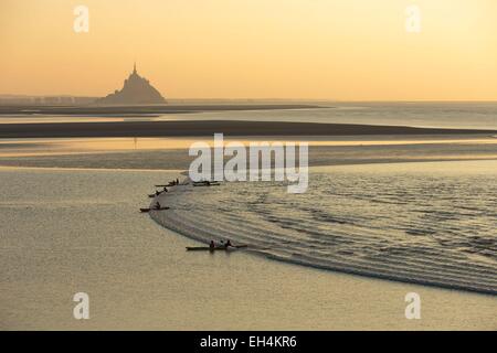 France, Manche, Mont Saint Michel bay, listed as World Heritage by UNESCO, a kayakists riding the Mascaret wave during fall high tides and Tombelaine islet in the background Stock Photo