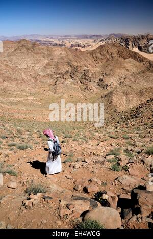 Jordan, Wadi Rum desert, border with Saudi Arabia, Bedouin walking on the mountain Jebel Umm Adaami (1832m), the highest mountain of Jordan Stock Photo