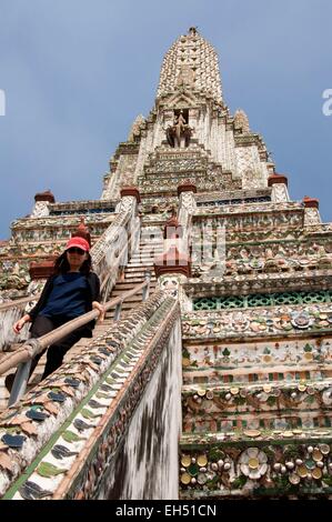 Thailand, Bangkok, Wat Arun, woman going down the steep stairs (model release) Stock Photo