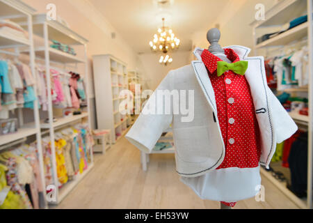 White jacket with red shirt on a mannequin placed in a children's clothing store Stock Photo