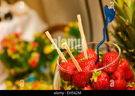 Fresh Strawberries with toothpicks stuck in them, placed in a glass bowl Stock Photo