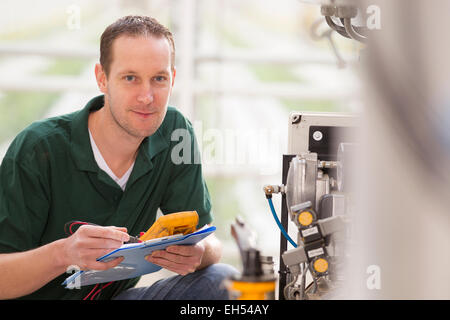 Senior technician repairing agriculture machinery in a greenhouse Stock Photo
