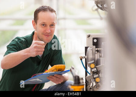 echnician repairing agriculture machinery and looking at camera Stock Photo
