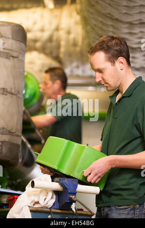 Senior technician and junior technician repairing agriculture machinery in a greenhouse Stock Photo
