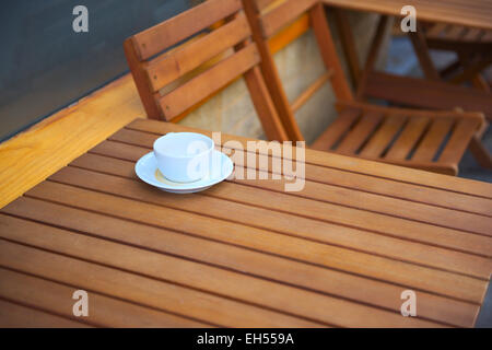 Empty coffee cup on outdoor wooden table Stock Photo