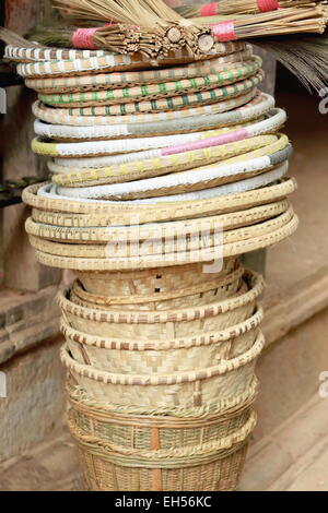 Set of wicker baskets and trays topped with natural fiber traditional brooms on the outside of a handicrafts shop-Panauti-Nepal. Stock Photo