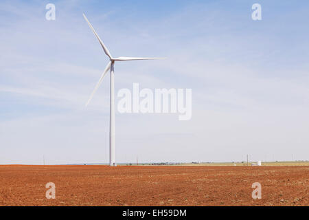 Windmill for generating electricity in freshly plowed hay field with heat shimmer, Kiowa County, Oklahoma Stock Photo
