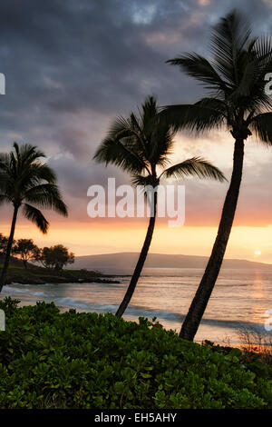 Setting sun silhouettes offshore Kahoolawe Island from Makena Beach on Hawaii's island of Maui. Stock Photo