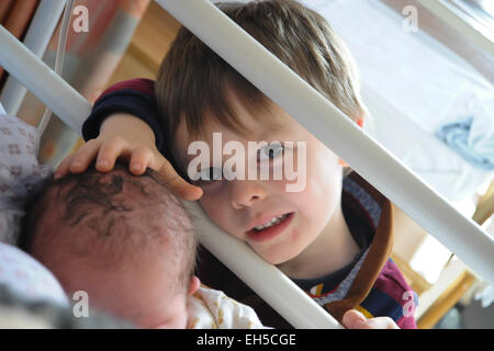 A big brother meets his newborn little baby brother for the first time in hospital Stock Photo